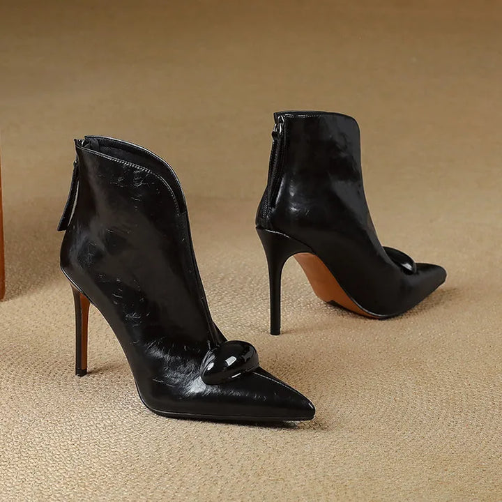 Pair of black pointed toe ankle boots on floor