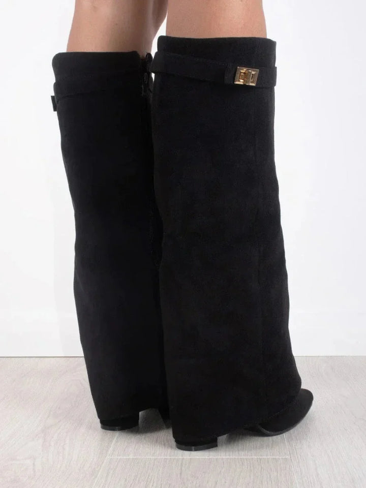 Bottes en suède noir pour femme, avec détails métalliques et design classique.