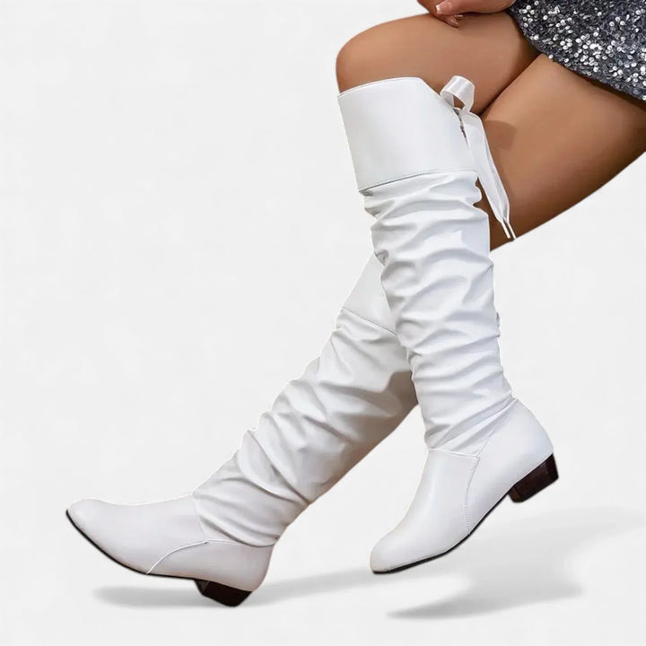 Bottes mi-hautes rouges en simili cuir, avec nœud décoratif et talon bas.