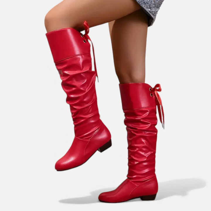 Bottes mi-hautes blanches en cuir souple, avec nœud décoratif et talon bas pour un confort optimal.