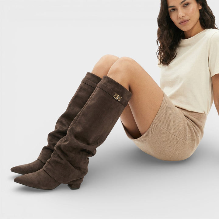 Bottes froncées hautes, bout pointu, talon bas, boucle.