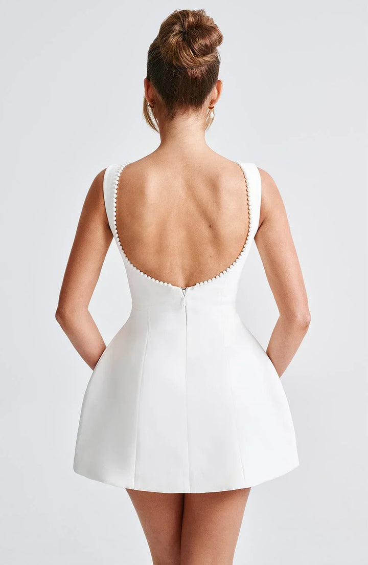 Robe courte femme en coton, avec nœud décoratif au dos et un design élégant. Parfaite pour les occasions décontractées.