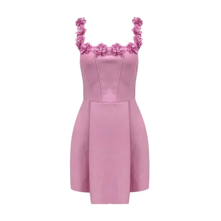 Robe courte rose sans manches avec encolure florale, en tissu léger, idéal pour les fêtes d'été. Détails floraux délicats.