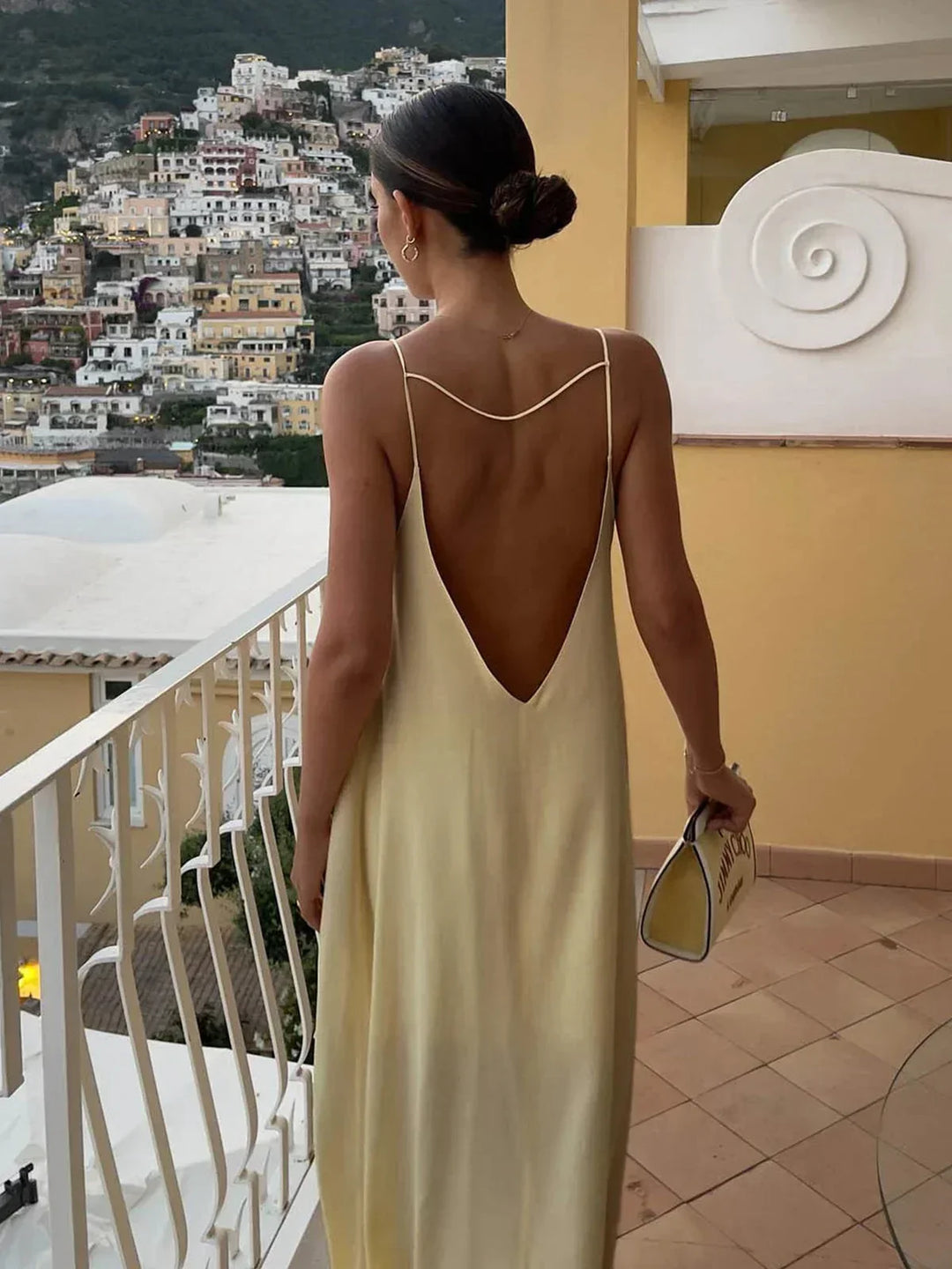Robe longue jaune en tissu léger, dos nu avec fines bretelles, idéale pour les journées d'été ensoleillées.