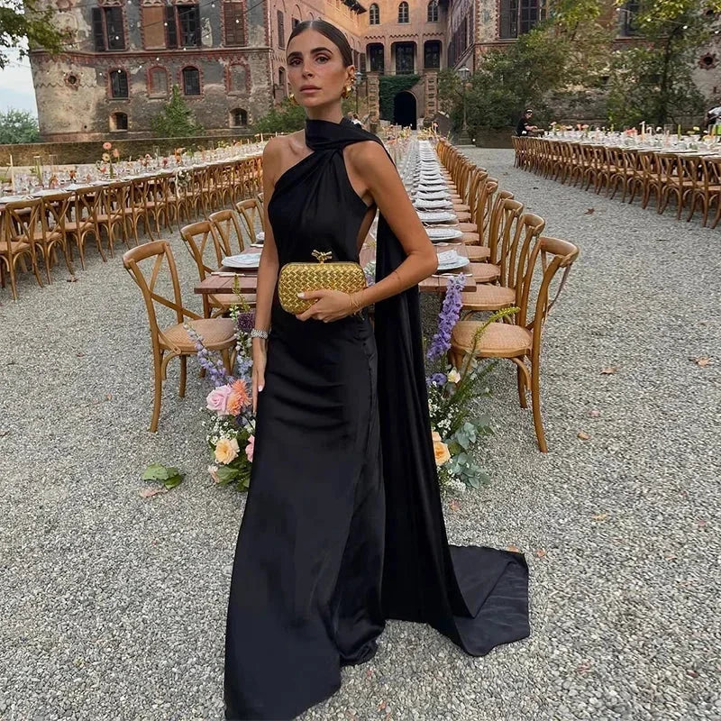 Robe longue noire avec drapé élégant et bretelle unique, confectionnée en tissu doux et fluide pour un confort optimal.