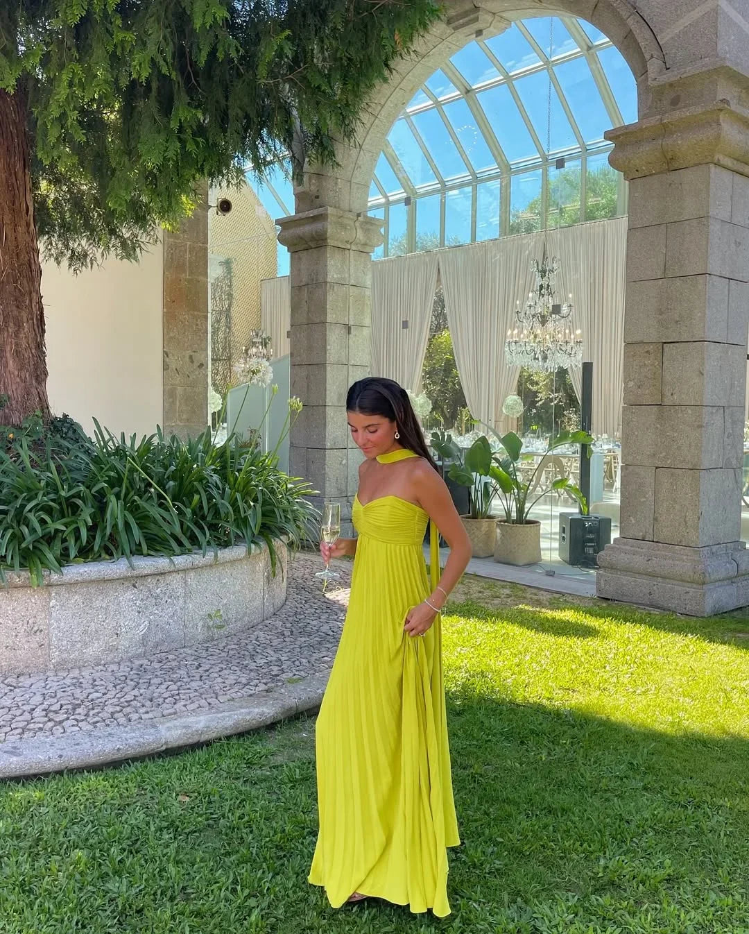 Robe longue femme jaune pliée en tissu léger, avec un décolleté en V et des bretelles fines, parfaite pour l'été.
