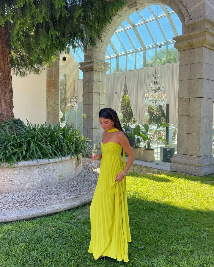 Robe longue femme jaune pliée en tissu léger, avec un décolleté en V et des bretelles fines, parfaite pour l'été.
