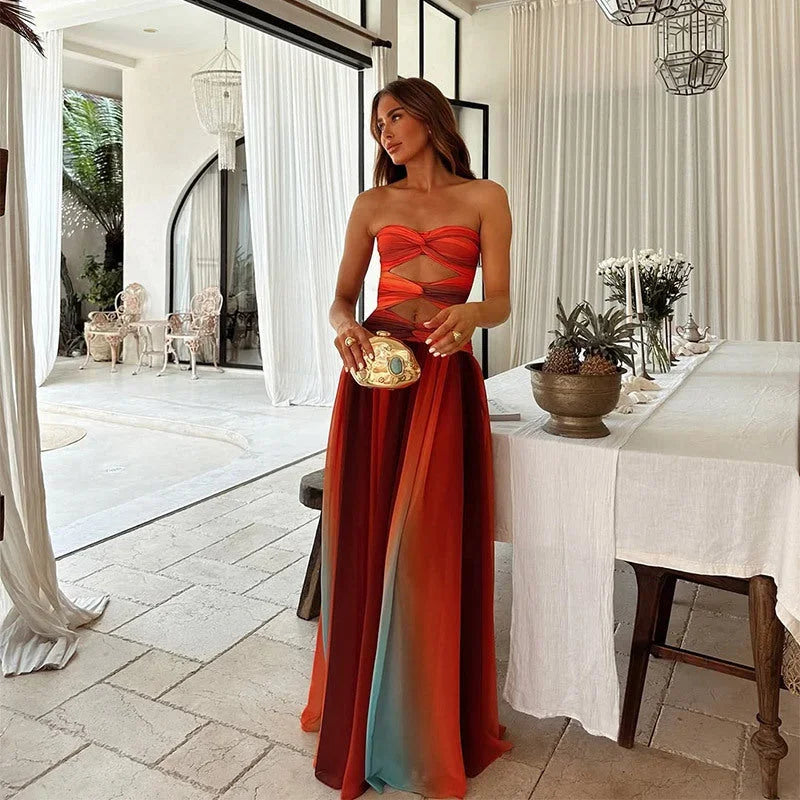 Robe longue sans bretelles rouge et orange, en tissu léger, avec motifs blocs pour une allure estivale décontractée.