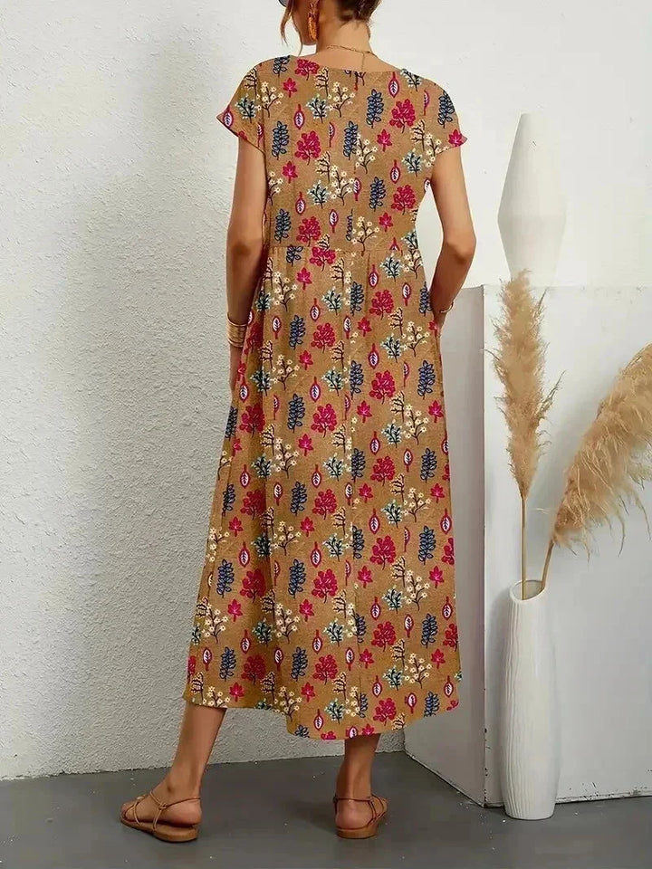 Robe midi en coton avec imprimé floral, manches courtes et poches latérales pratiques, idéale pour les journées ensoleillées.