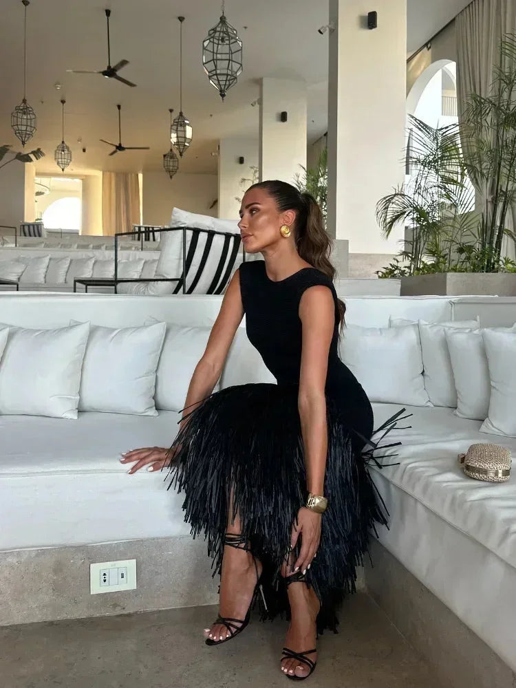 Robe midi noire sans manches en tissu léger, ornée de franges élégantes pour un style unique, idéale pour les soirées.