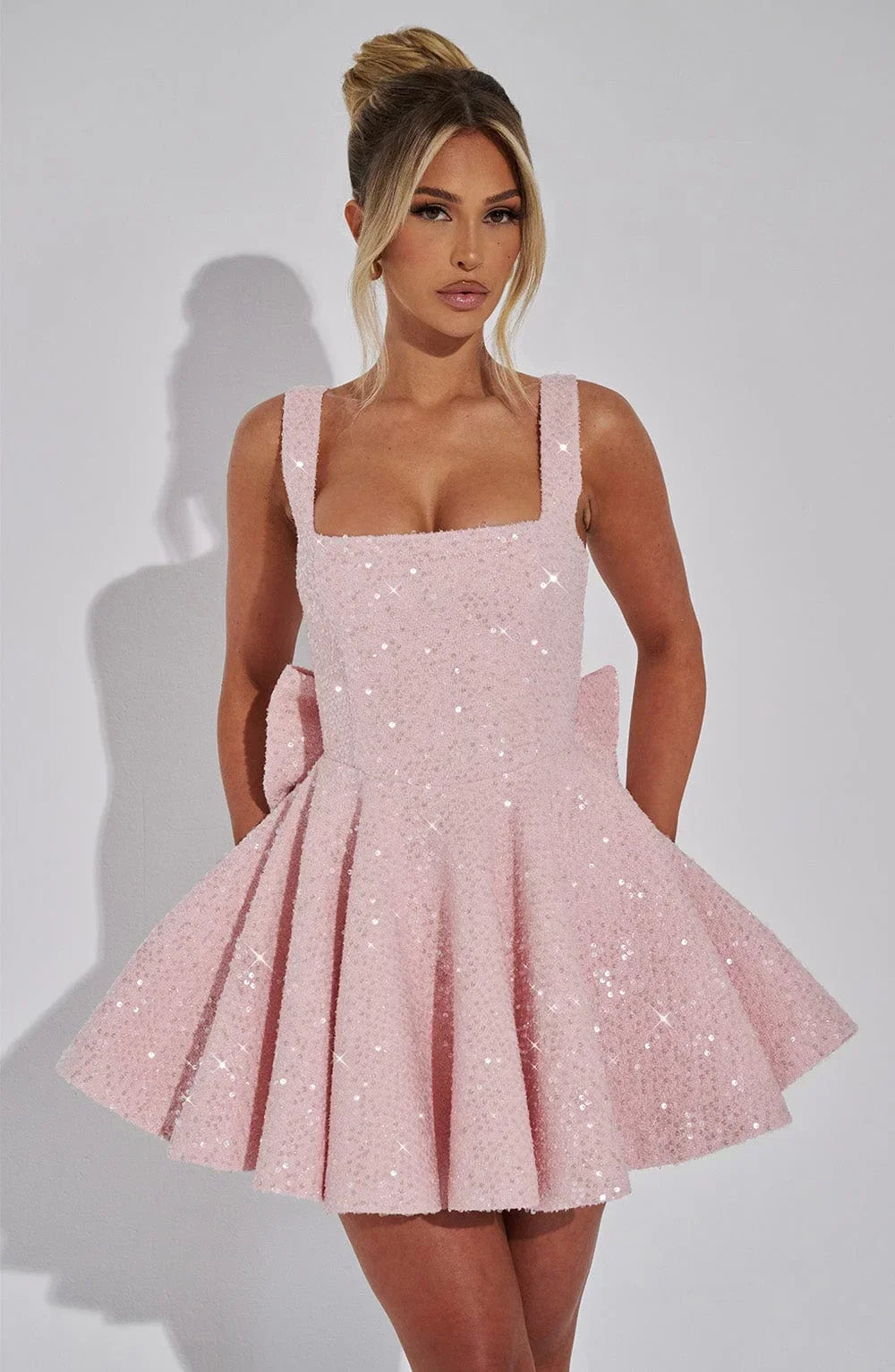 Alt text : Robe courte pailletée fit and flare, en tissu léger avec nœud décoratif, idéale pour soirées clubbing.