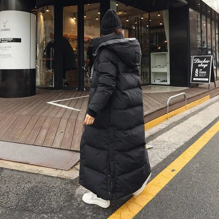 Doudoune longue noire pour femme avec capuche amovible et poches pratiques, idéale pour l'hiver.